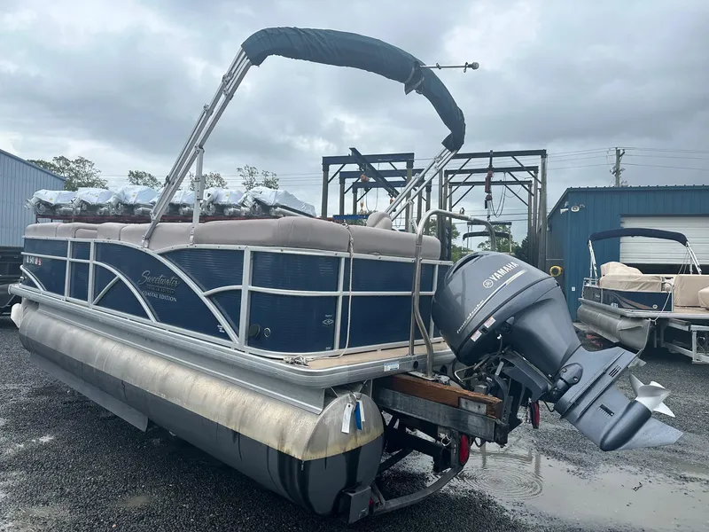 Slide: The Image of 2015 Godfrey Sweetwater 20PE pontoon boat with Yamaha outboard motor, parked on gravel. - 2