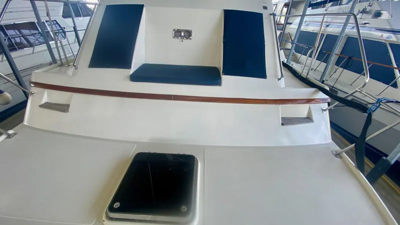 Slide: The Image of 1989 Kadey-Krogen Manatee 36 yacht deck with blue cushions and wooden accents. - 16