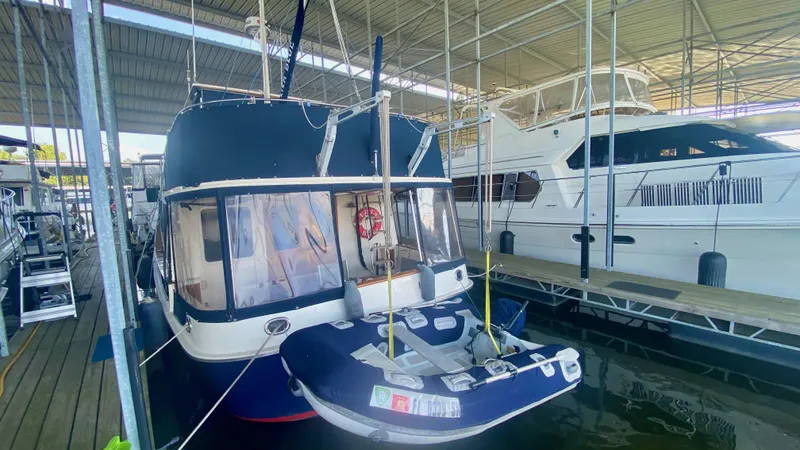 Slide: The Image of 1989 Kadey-Krogen Manatee 36 docked with inflatable boat, under covered marina. - 19