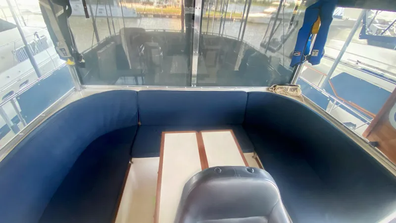 Slide: The Image of 1989 Kadey-Krogen Manatee 36 interior with blue seating and table, docked at marina. - 22