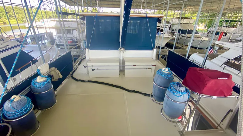 Slide: The Image of 1989 Kadey-Krogen Manatee 36 yacht deck with blue covers and docked boats in marina. - 24