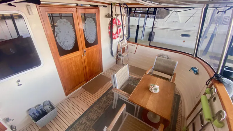Slide: The Image of 1989 Kadey-Krogen Manatee 36 yacht interior with wooden doors, table, chairs, and nautical decor. - 30