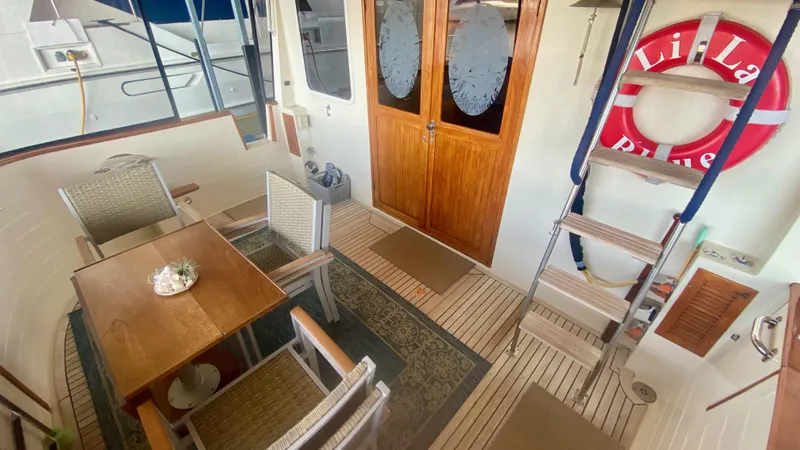 Slide: The Image of 1989 Kadey-Krogen Manatee 36 yacht interior with dining area, wooden flooring, and life preserver. - 31