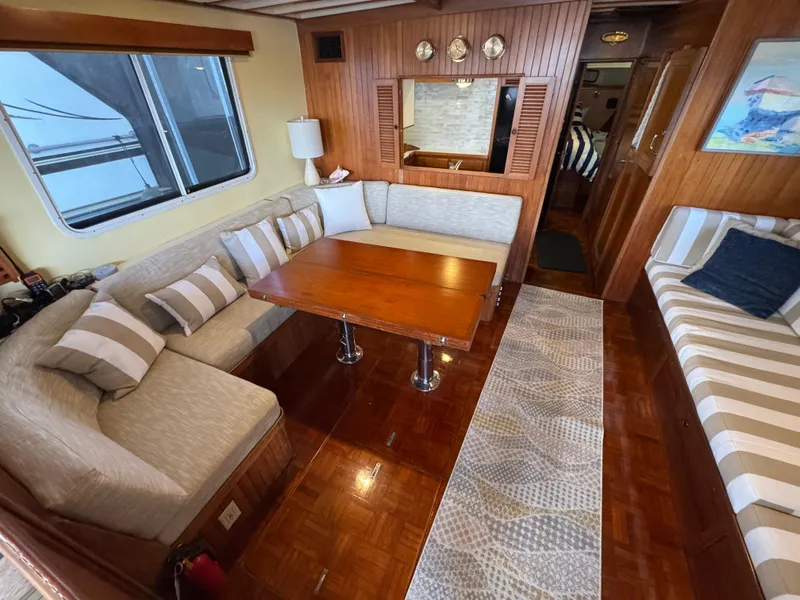 Slide: The Image of 1989 Kadey-Krogen Manatee 36 interior with cozy seating, wooden table, and nautical decor. - 32