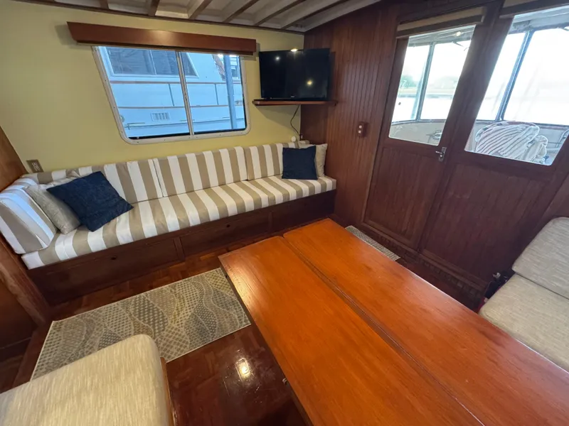 Slide: The Image of Interior of 1989 Kadey-Krogen Manatee 36 with striped sofa, wooden table, and mounted TV. - 34