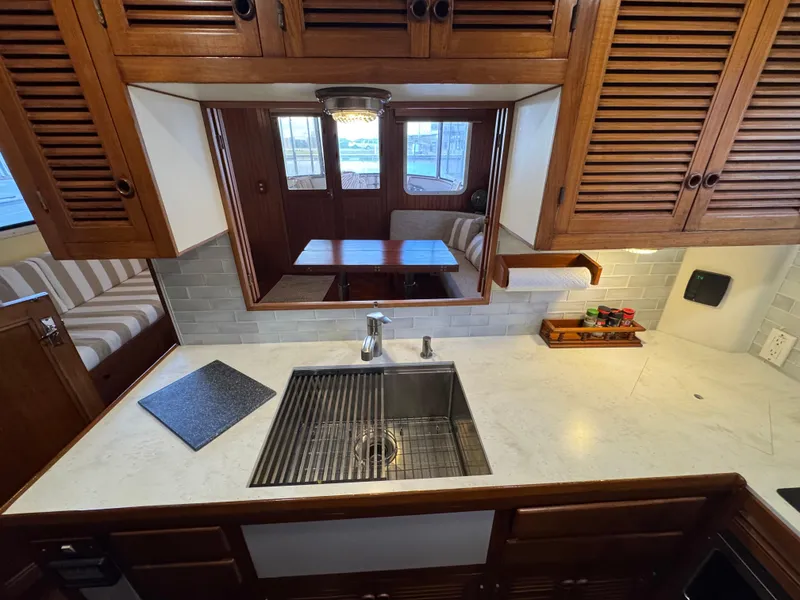 Slide: The Image of 1989 Kadey-Krogen Manatee 36 galley with wooden cabinets, marble countertop, and stainless steel sink. - 36