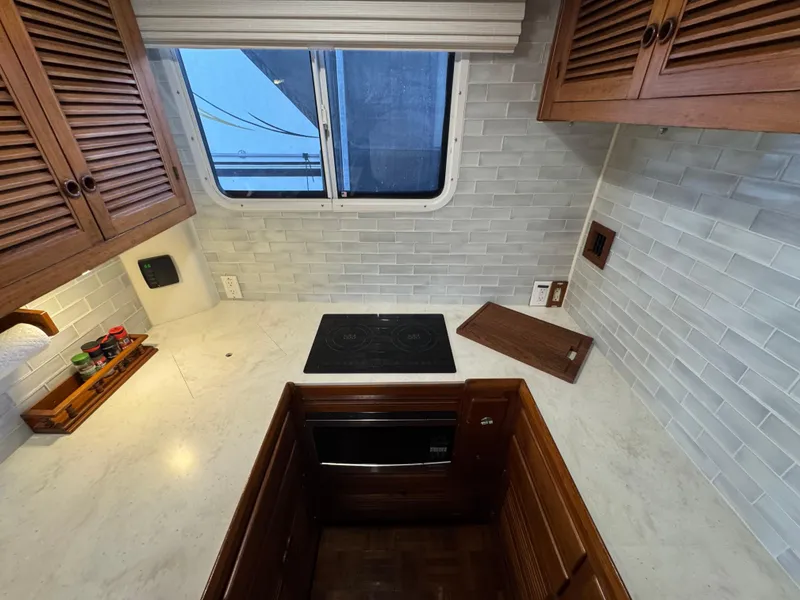 Slide: The Image of 1989 Kadey-Krogen Manatee 36 kitchen with stove, wooden cabinets, and tiled backsplash. - 37