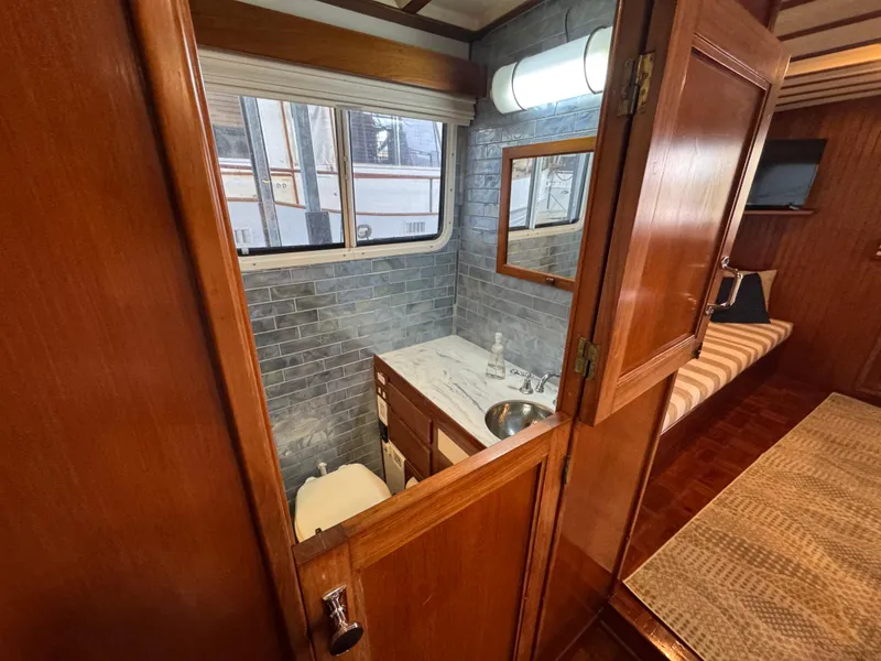 Slide: The Image of 1989 Kadey-Krogen Manatee 36 yacht interior with wooden cabinetry and compact bathroom. - 38