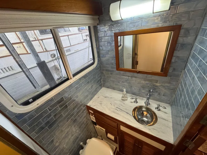 Slide: The Image of 1989 Kadey-Krogen Manatee 36 bathroom with marble countertop, stainless sink, and blue tile walls. - 39