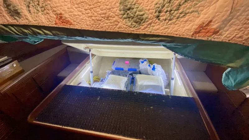 Slide: The Image of Under-bed storage in 1989 Kadey-Krogen Manatee 36, filled with various items. - 45