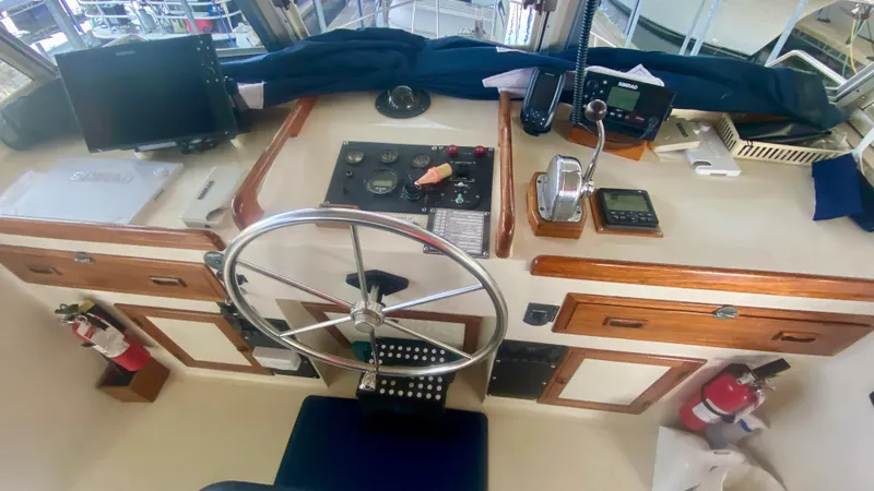 Slide: The Image of 1989 Kadey-Krogen Manatee 36 helm with steering wheel, navigation instruments, and wooden cabinetry. - 47