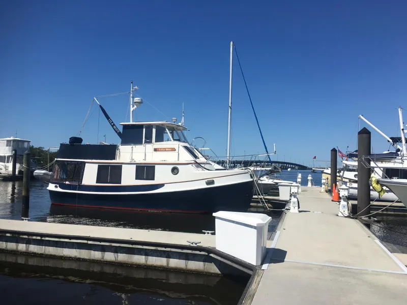 Slide: The Image of 1989 Kadey-Krogen Manatee 36 docked at marina under clear blue sky. - 5