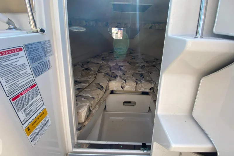 Slide: The Image of Interior cabin of a 2000 Sea Ray 230 boat with cushioned seating. - 12