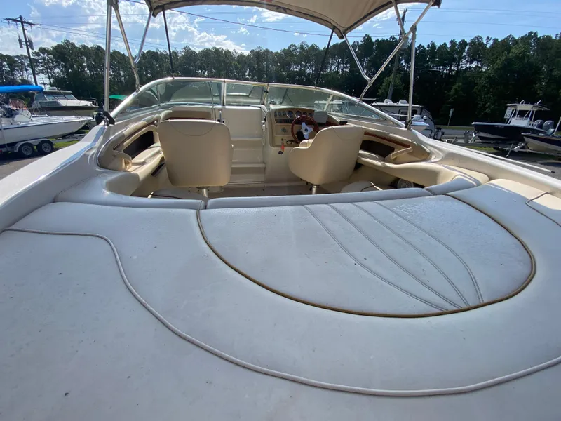 Slide: The Image of 2000 Sea Ray 230 boat interior with seating and canopy, docked outdoors. - 4