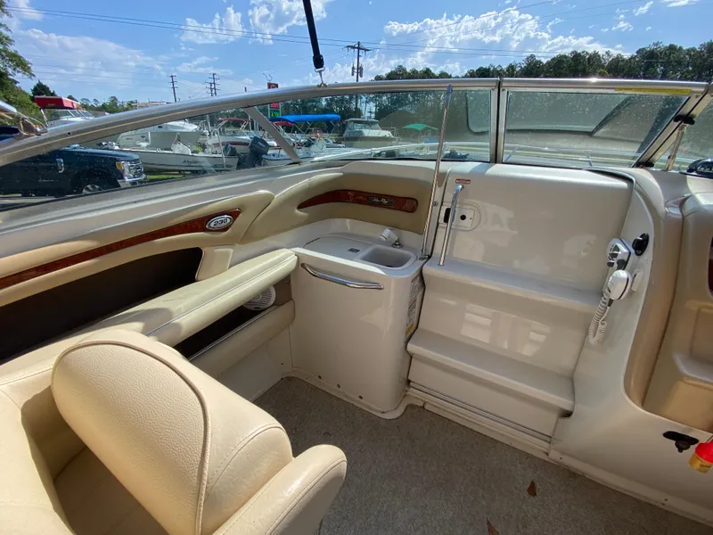 Slide: The Image of Interior of a 2000 Sea Ray 230 boat with beige seating and dashboard. - 6