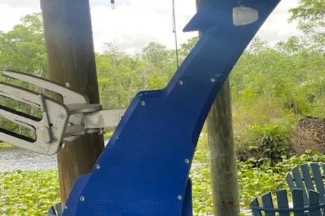 Slide: The Image of Blue Malibu Wakesetter 25 LSV boat part near a lake with greenery, 2016 model. - 18