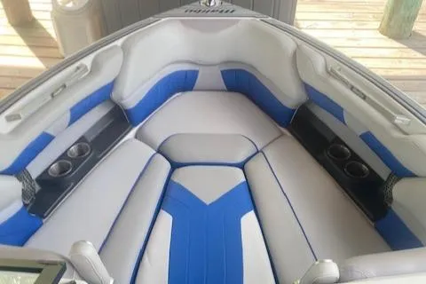 Slide: The Image of 2016 Malibu Wakesetter 25 LSV boat interior with blue and gray seating. - 9