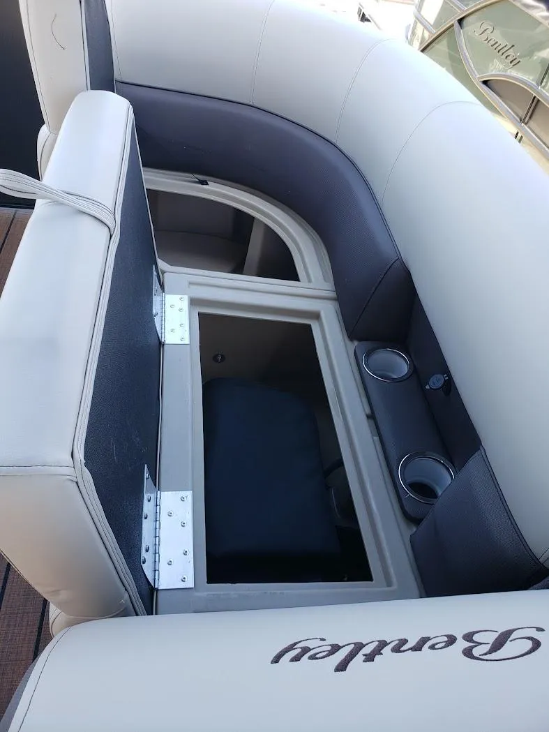 Slide: The Image of 2025 Bentley Pontoons Legacy Navigator seating with storage and cup holders. - 4