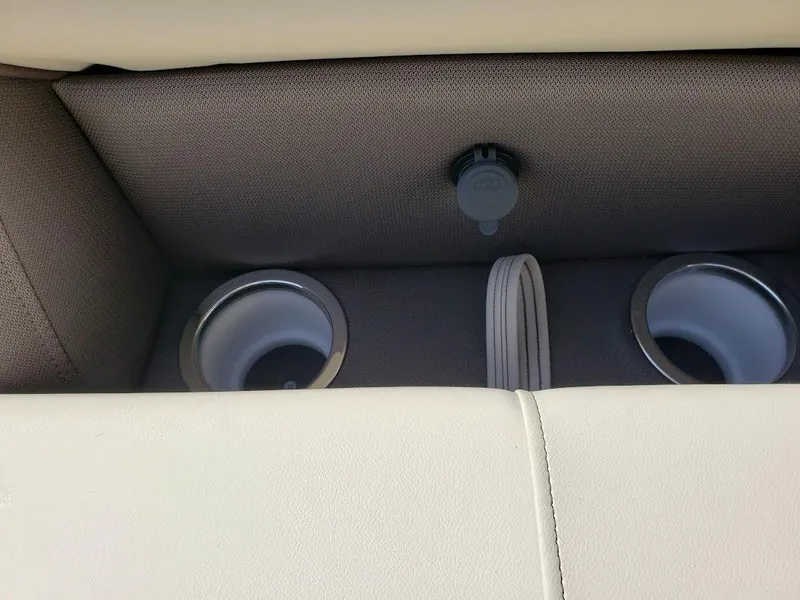 Slide: The Image of 2025 Bentley Pontoons Legacy Navigator cup holders and USB port on beige seating. - 9