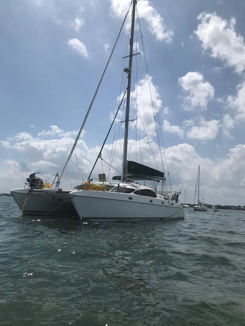 Slide: The Image of 1996 Prout 45 catamaran sailing on a sunny day with scattered clouds. - 0