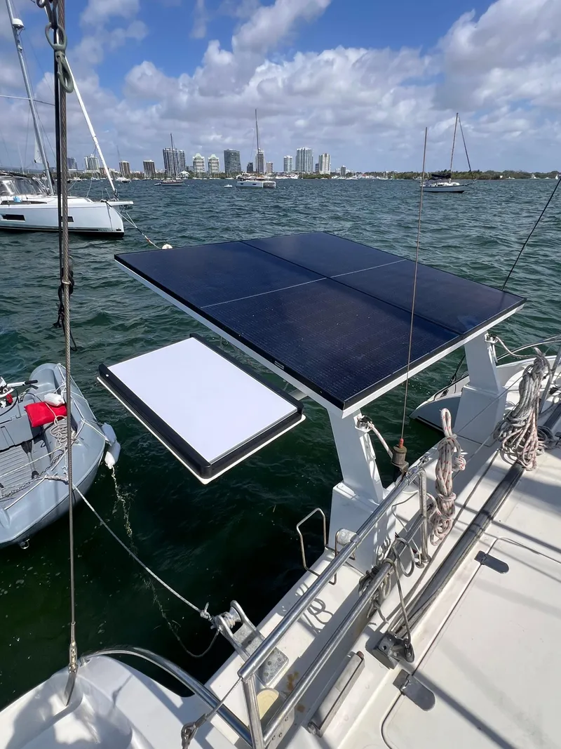 Slide: The Image of Sailboat with solar panels on deck, Prout 45, 1996, anchored near city skyline. - 14
