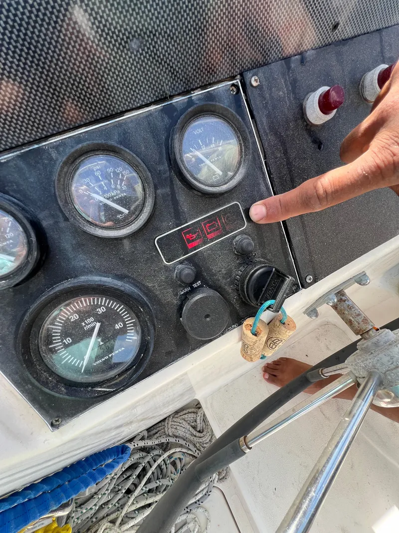Slide: The Image of Control panel of a 1996 Prout 45 boat with gauges and a pointing hand. - 26