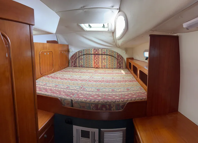 Slide: The Image of Cozy cabin interior of 1996 Prout 45 yacht with patterned bedding and wooden furnishings. - 29