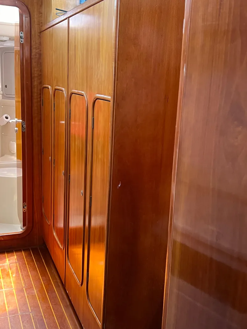 Slide: The Image of Wood-paneled interior of a 1996 Prout 45 yacht, featuring sleek cabinets and a bathroom door. - 31