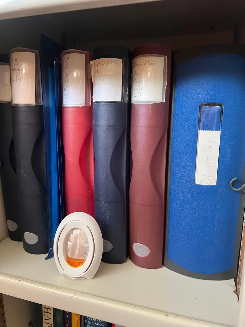 Slide: The Image of Shelf with assorted binders and a small decorative item, Prout 45, 1996. - 38