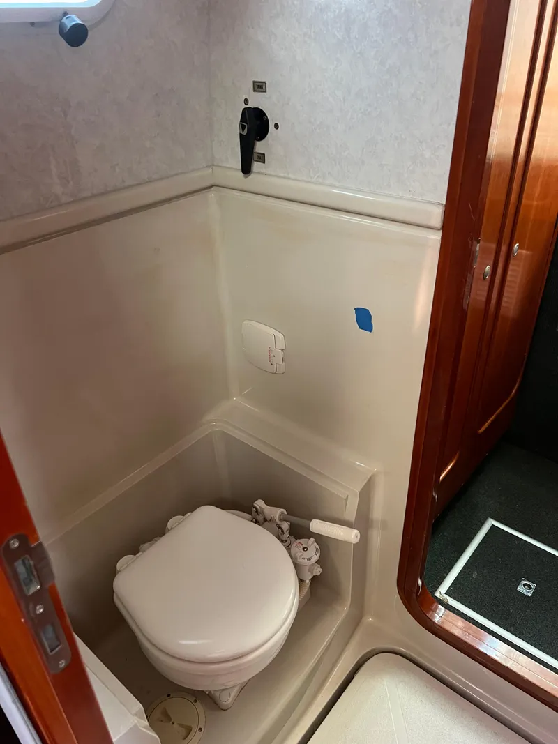Slide: The Image of 1996 Prout 45 yacht bathroom with compact marine toilet and wooden door. - 45
