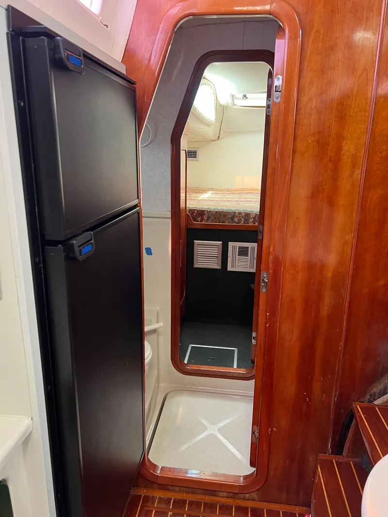 Slide: The Image of Interior of 1996 Prout 45 yacht with wooden paneling and compact kitchen area. - 46
