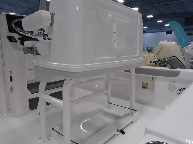 Slide: The Image of 2025 Caymas 24 HB boat interior with white console and seating in a showroom. - 10