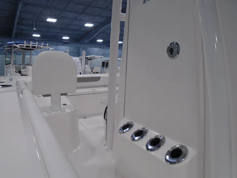 Slide: The Image of 2025 Caymas 24 HB boat interior with rod holders and seating in a showroom. - 13