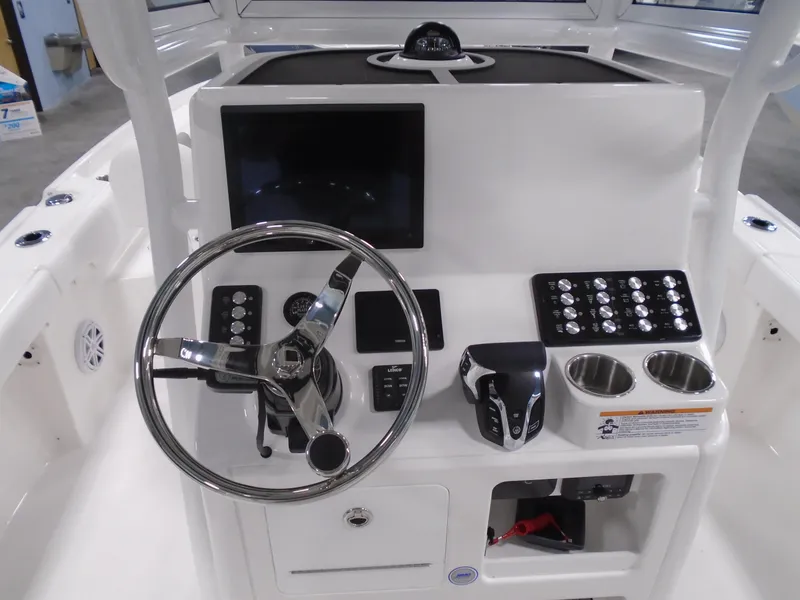 Slide: The Image of 2025 Caymas 24 HB boat console with steering wheel, controls, and cup holders. - 18
