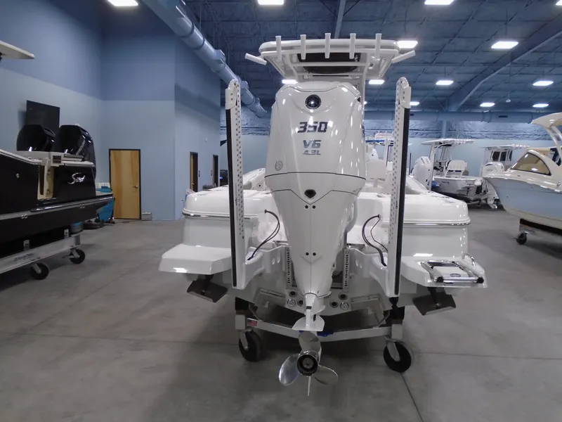 Slide: The Image of 2025 Caymas 24 HB boat with powerful 350 V6 engine in showroom. - 2