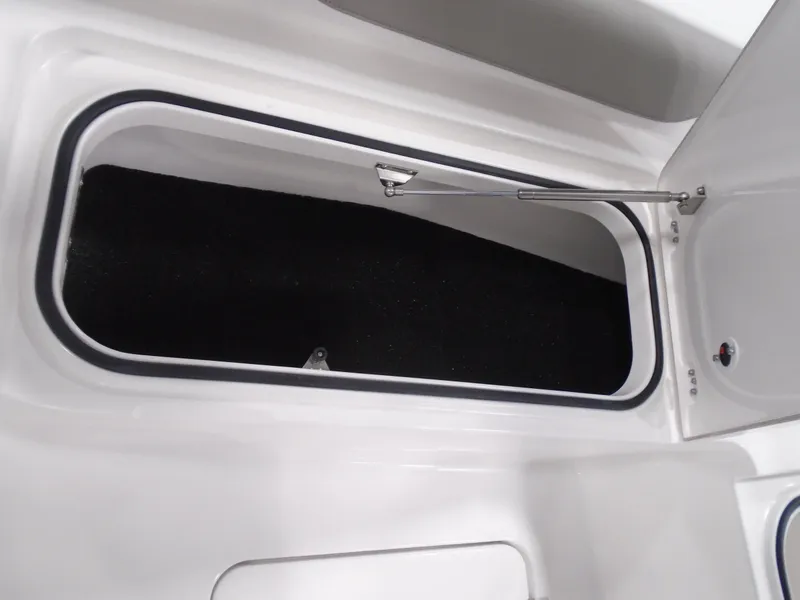 Slide: The Image of 2025 Caymas 24 HB boat storage compartment, open hatch, white interior. - 21