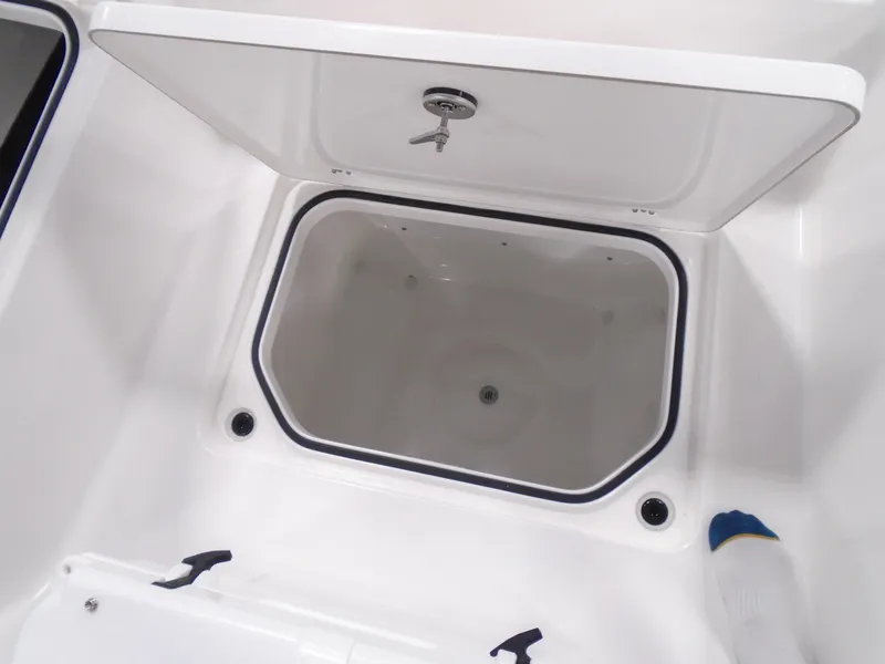 Slide: The Image of 2025 Caymas 24 HB boat storage compartment with open lid, showcasing interior space. - 22