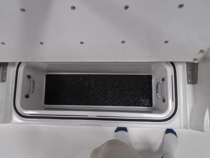 Slide: The Image of 2025 Caymas 24 HB boat storage compartment with handles and non-slip surface. - 24
