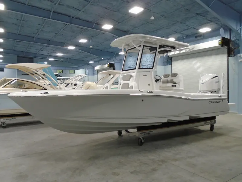 Slide: The Image of 2025 Caymas 24 HB boat in showroom, sleek design, white exterior, modern features. - 5