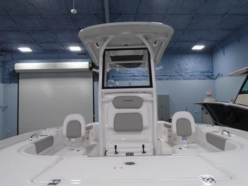 Slide: The Image of 2025 Caymas 24 HB boat interior with seating and console in a showroom. - 6