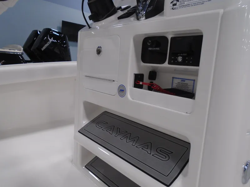 Slide: The Image of 2025 Caymas 24 HB boat console with storage compartments and branded step mat. - 9
