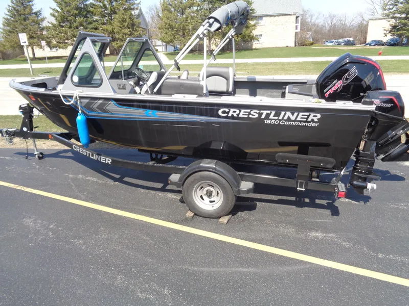 Slide: The Image of 2017 Crestliner CCM185 boat on trailer, parked outdoors, with visible motor and windshield. - 3
