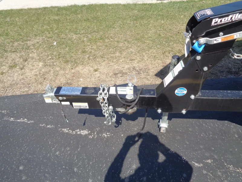 Slide: The Image of Trailer hitch of a 2017 Crestliner CCM185 on asphalt, with safety chains and shadow visible. - 9