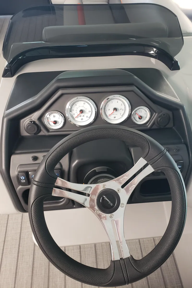 Slide: The Image of 2025 Bentley Pontoons Legacy Navigator dashboard with steering wheel and gauges. - 2