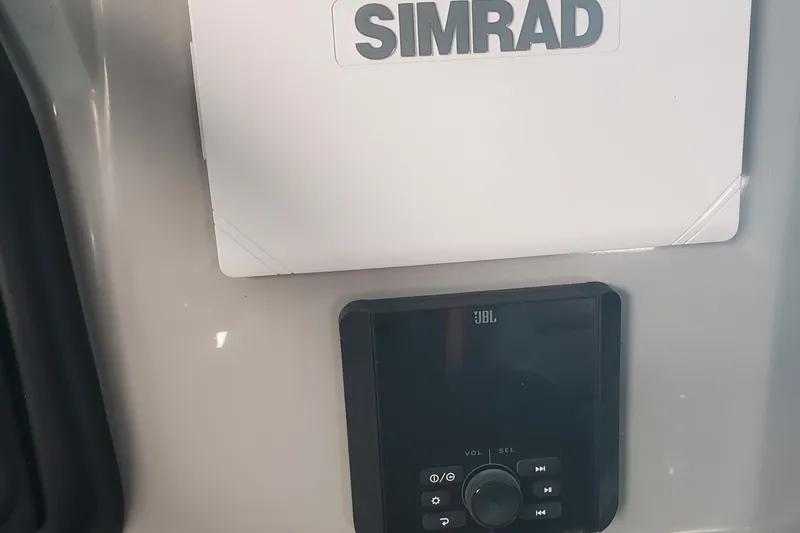 Slide: The Image of 2025 Bentley Pontoons Legacy Navigator dashboard with Simrad and JBL controls. - 3