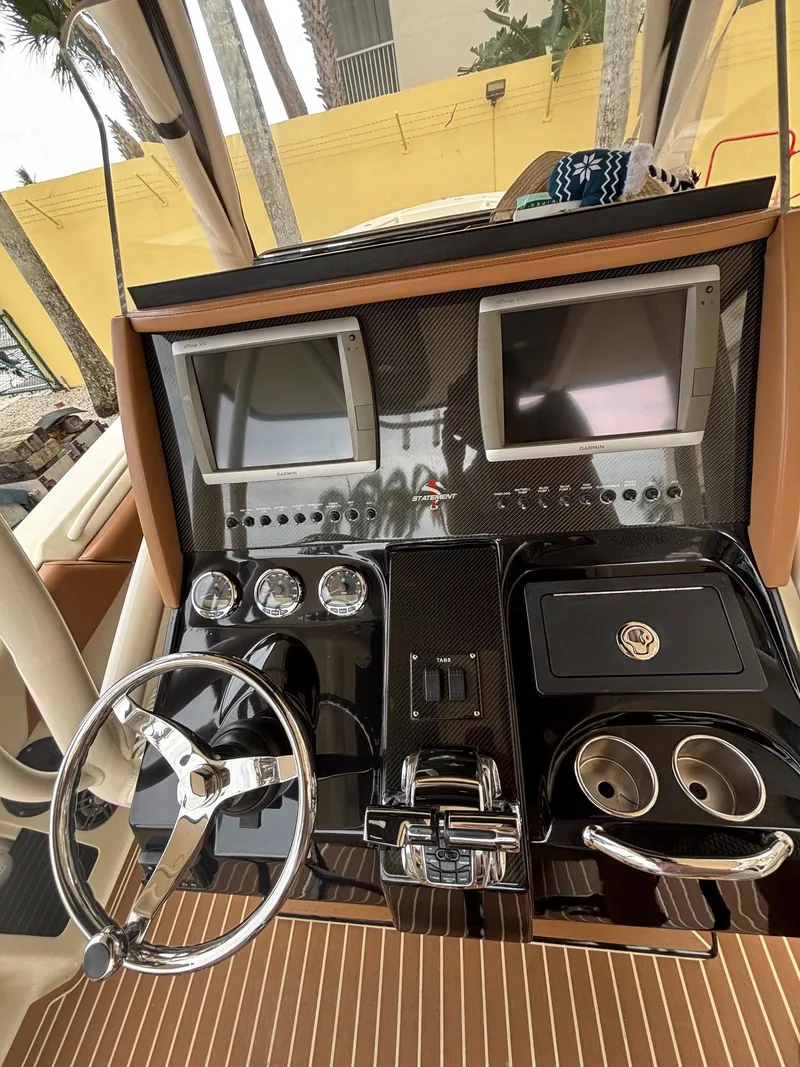 Slide: The Image of Control panel of a 2013 Statement 35 Center Console boat with dual screens and steering wheel. - 12