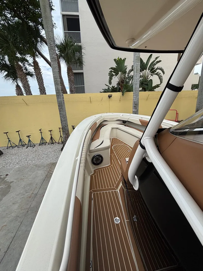 Slide: The Image of 2013 Statement 35 Center Console boat with sleek interior and wood accents, docked near palm trees. - 26