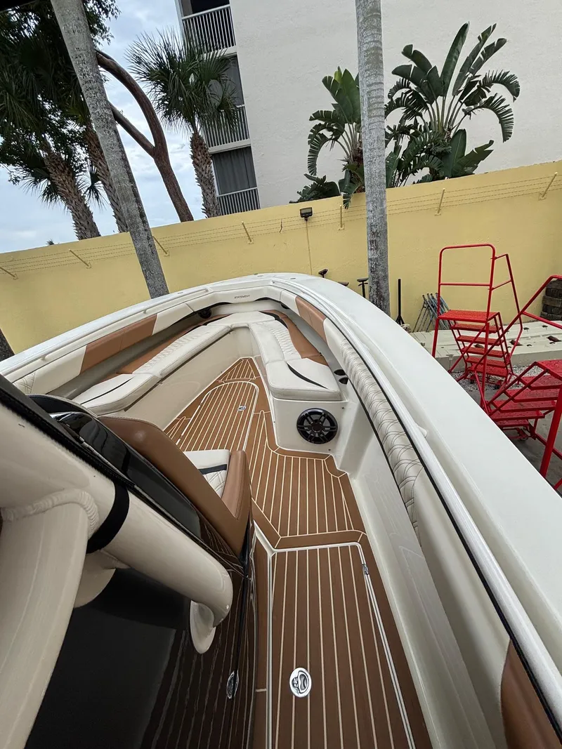 Slide: The Image of 2013 Statement 35 Center Console boat with sleek deck and seating, surrounded by tropical plants. - 27