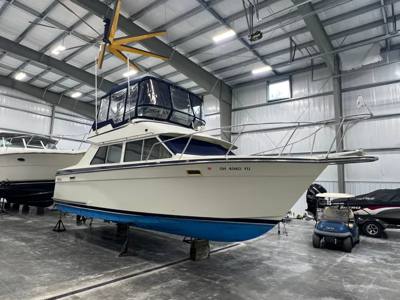 Slide: The Image of 1987 Tollycraft 30 Sport Cruiser in a storage facility, elevated on stands. - 1
