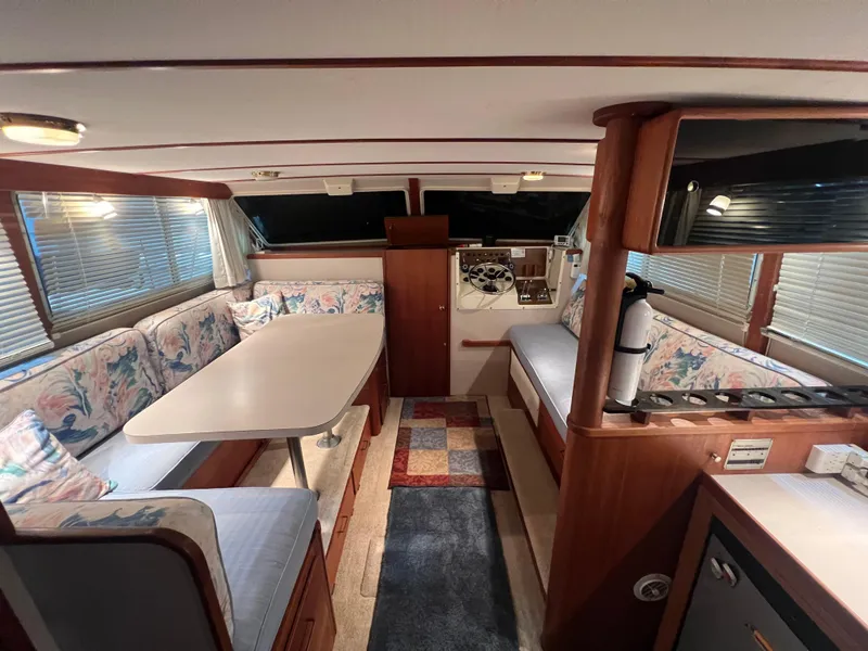 Slide: The Image of 1987 Tollycraft 30 Sport Cruiser interior with dining area, floral upholstery, and wood accents. - 11